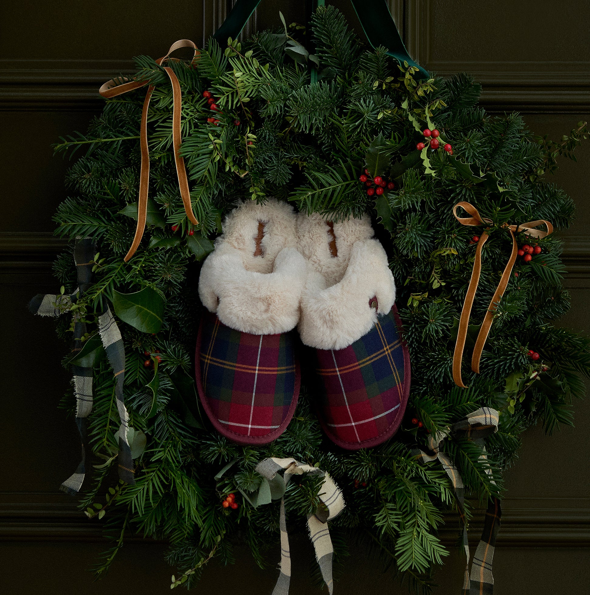Barbour CLAUDIA Womens Mule Slippers Winterberry Tartan displayed on a festive wreath background, showcasing the cozy slipper design.