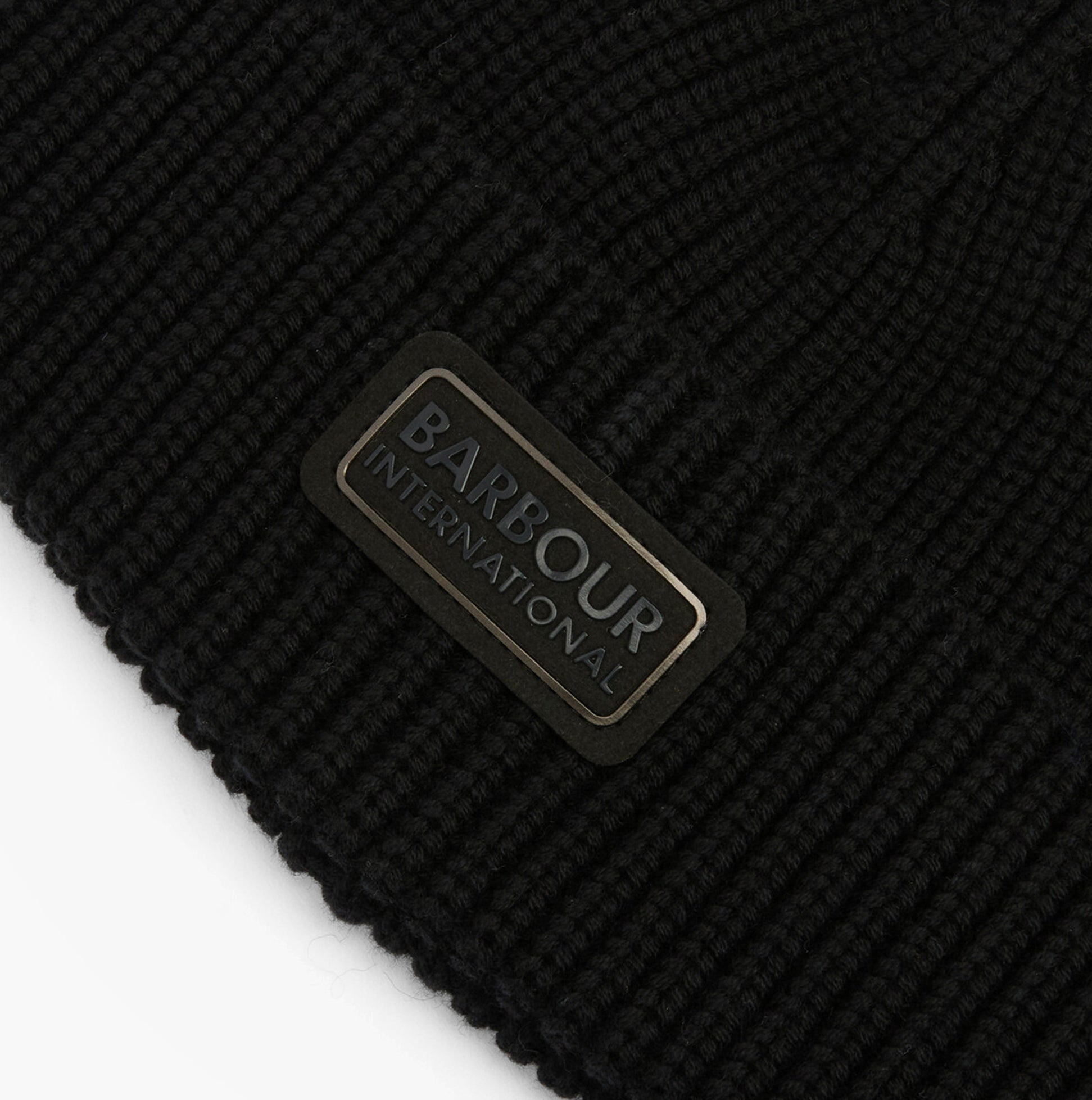 Detail view of Barbour SWEEPER BEANIE AND SCARF Mens Gift Set Black showing logo patch on black beanie.