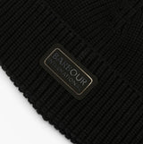 Detail view of Barbour SWEEPER BEANIE AND SCARF Mens Gift Set Black showing logo patch on black beanie.