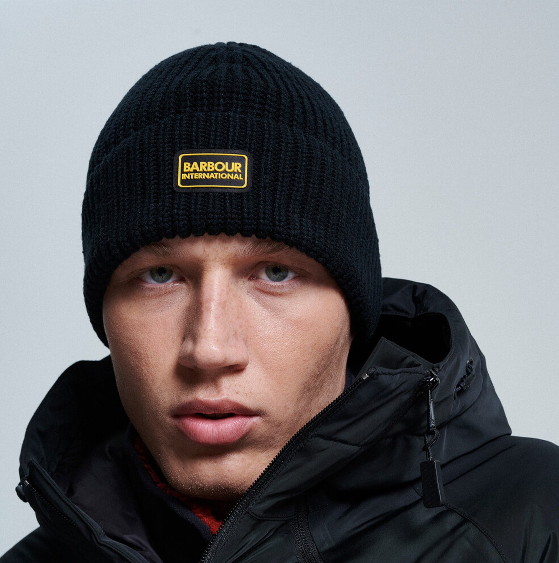 Barbour SWEEPER LEGACY Mens Beanie Black front view, showcasing ribbed design and silicone logo badge.