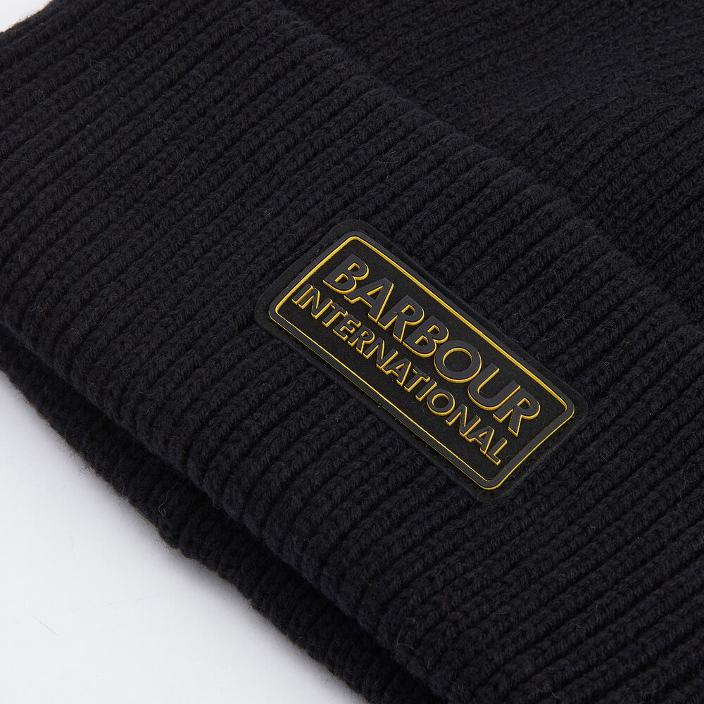 Barbour FLEX Mens Beanie Black detail view showing rubberised branded badge on outer