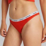 Calvin Klein ICON LOGO Womens Thong Molten side view showcasing the CK branded waistband and vibrant red color.