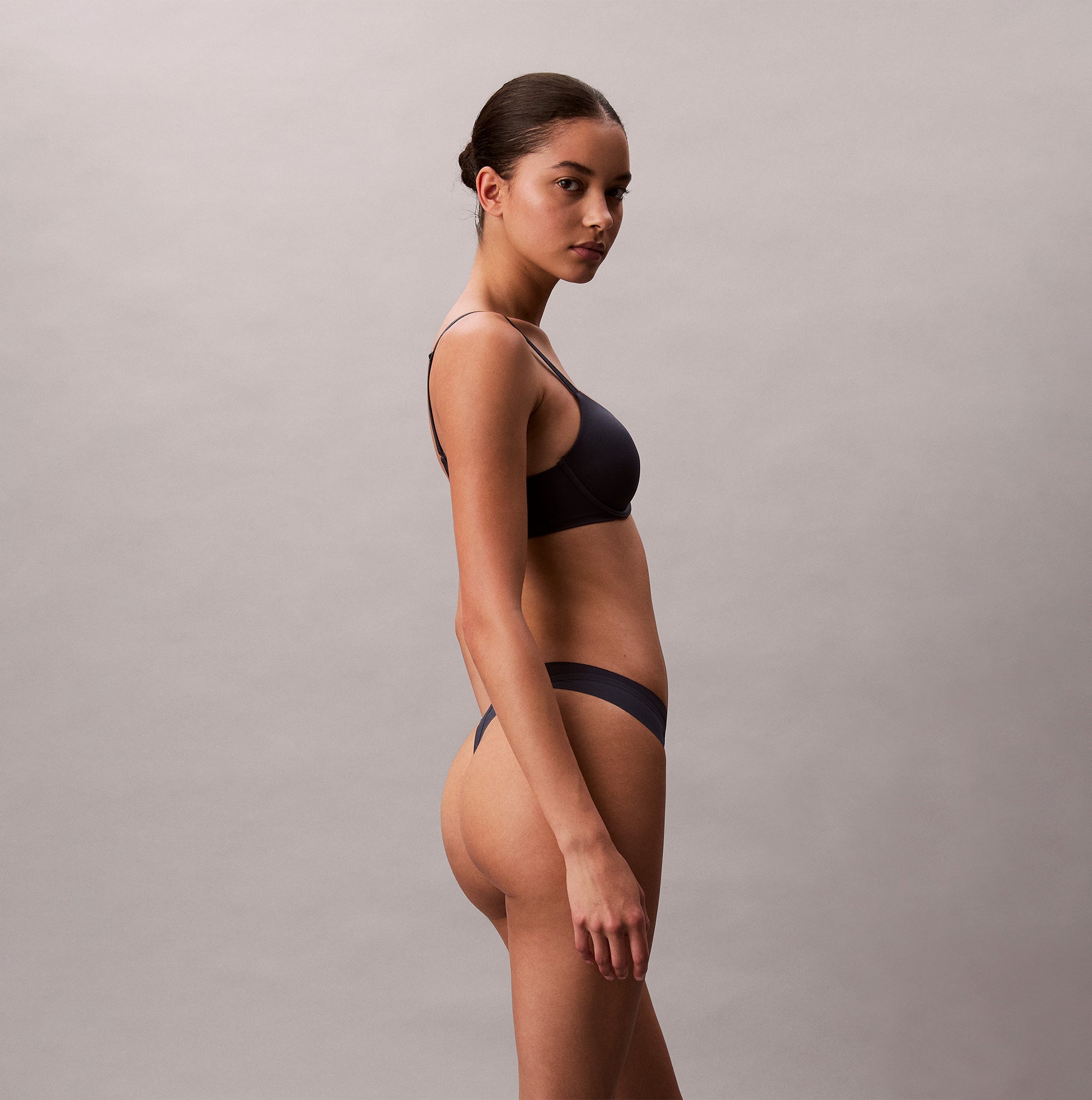 Calvin Klein Womens Invisible 3 Pack Thong Multi side view model wearing dark thong underwear