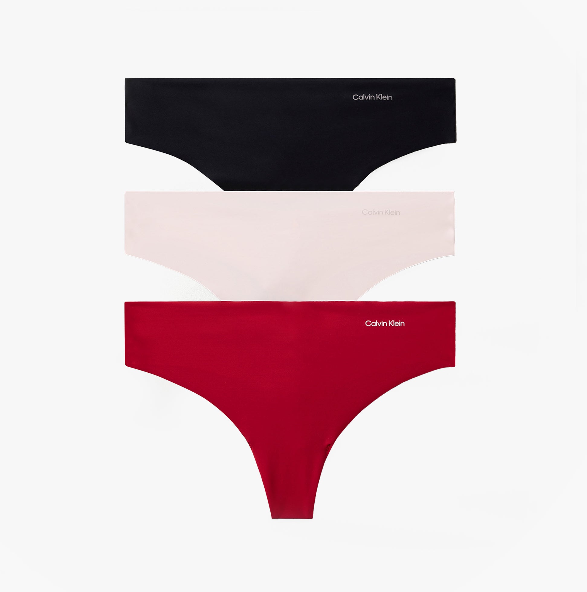 Calvin Klein Womens Invisible 3 Pack Thong Multi featuring black, nude, and red thongs in a flat lay view.