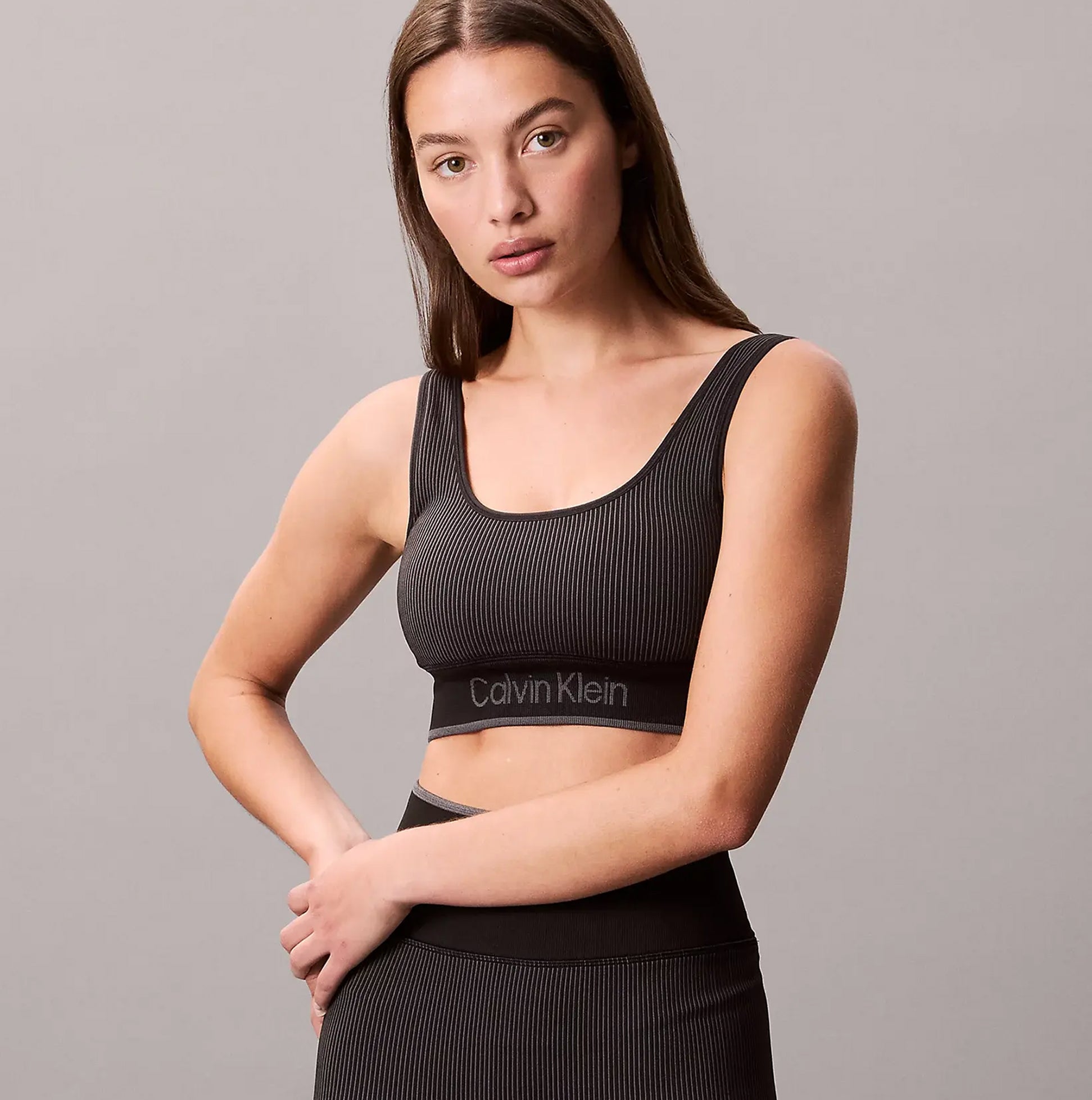 Calvin Klein Medium Impact Womens Sports Bra Black front view model wearing with logo detailing on band.