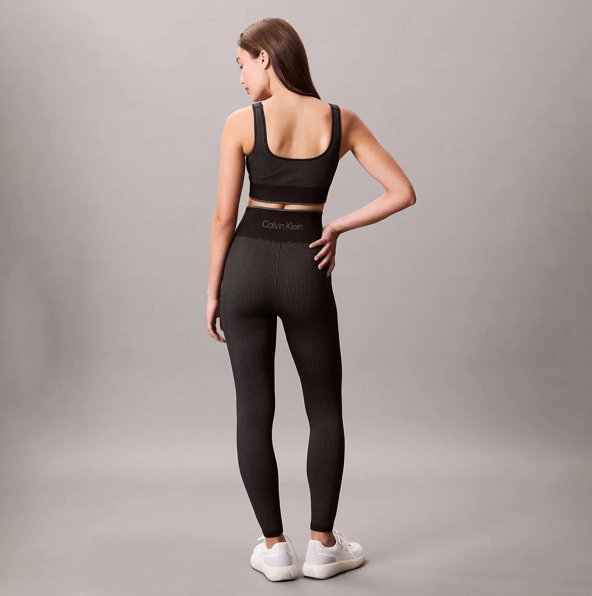 Calvin Klein Medium Impact Womens Sports Bra Black back view on model with matching black leggings.