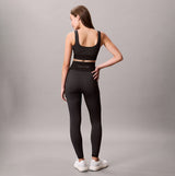 Calvin Klein Medium Impact Womens Sports Bra Black back view on model with matching black leggings.