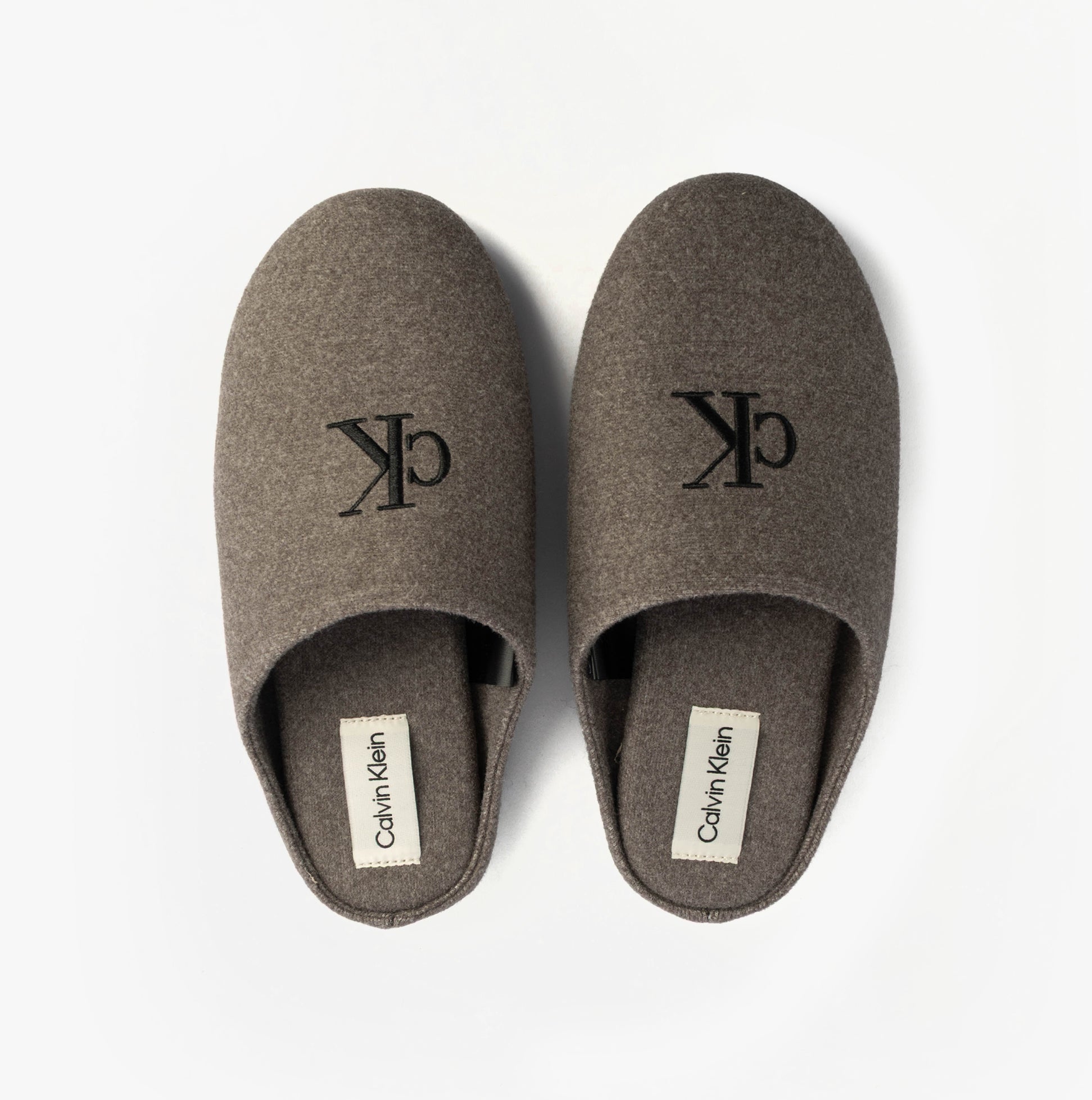 Calvin Klein Mens HOME Felt Signature Logo Mule Slippers Grey top view of the slippers showing logo and design.