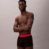 Calvin Klein TRUNK Mens 5 PACK Multicoloured side view model wearing black trunk with red waistband.