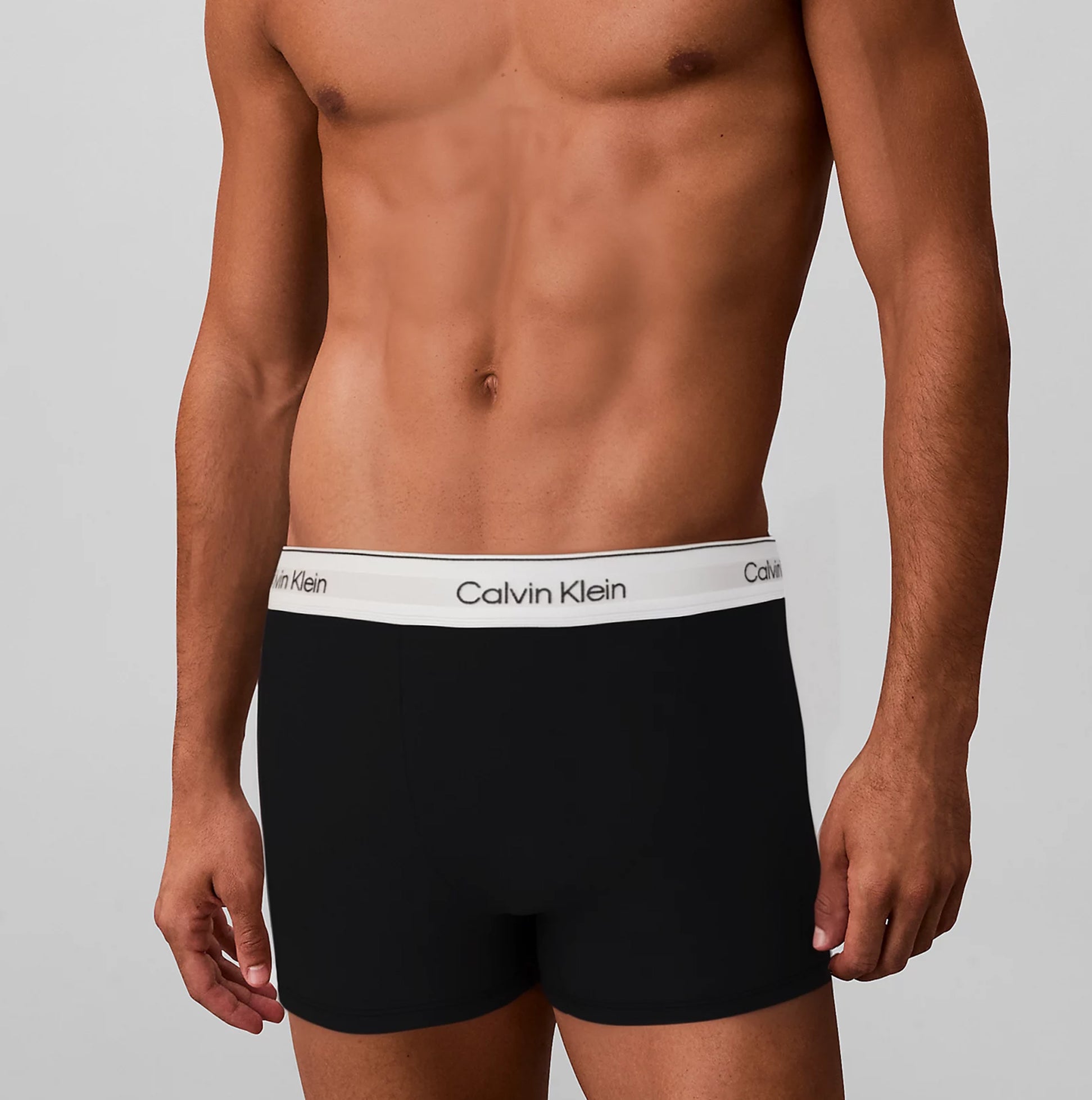 Calvin Klein RELAXED FIT 3 Pack Mens Trunks Multicoloured front view model wearing black trunks with logo waistband.
