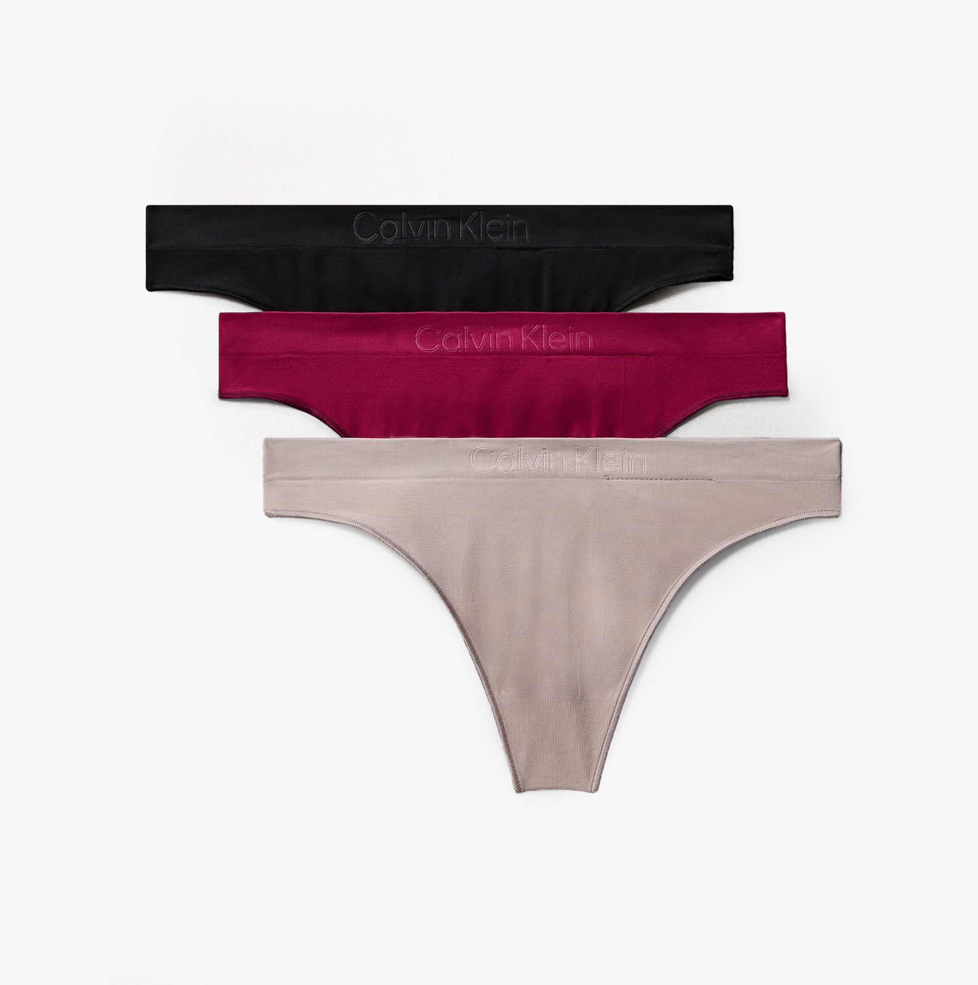 Calvin Klein Bonded Flex Seamless 3 Pack Thong Multi black, burgundy, and beige thongs stacked side view