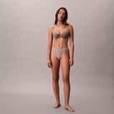 Calvin Klein Bonded Flex Seamless 3 Pack Thong Multi front view on model wearing seamless thong and bra in neutral colors.