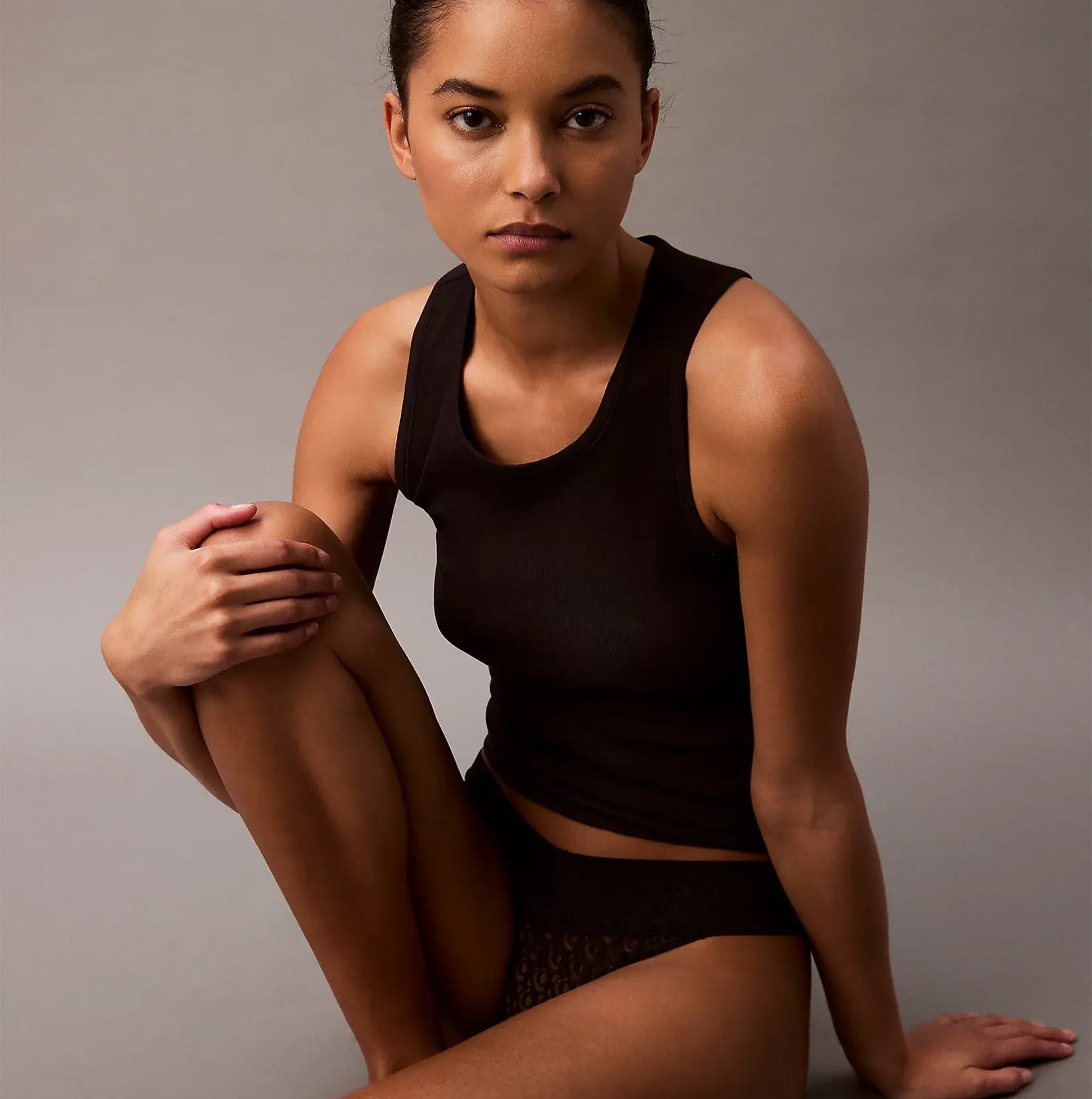 Calvin Klein THONG Womens Icon Logo Lace Molten Black side view on model with black tank top, showcasing lace detailing.