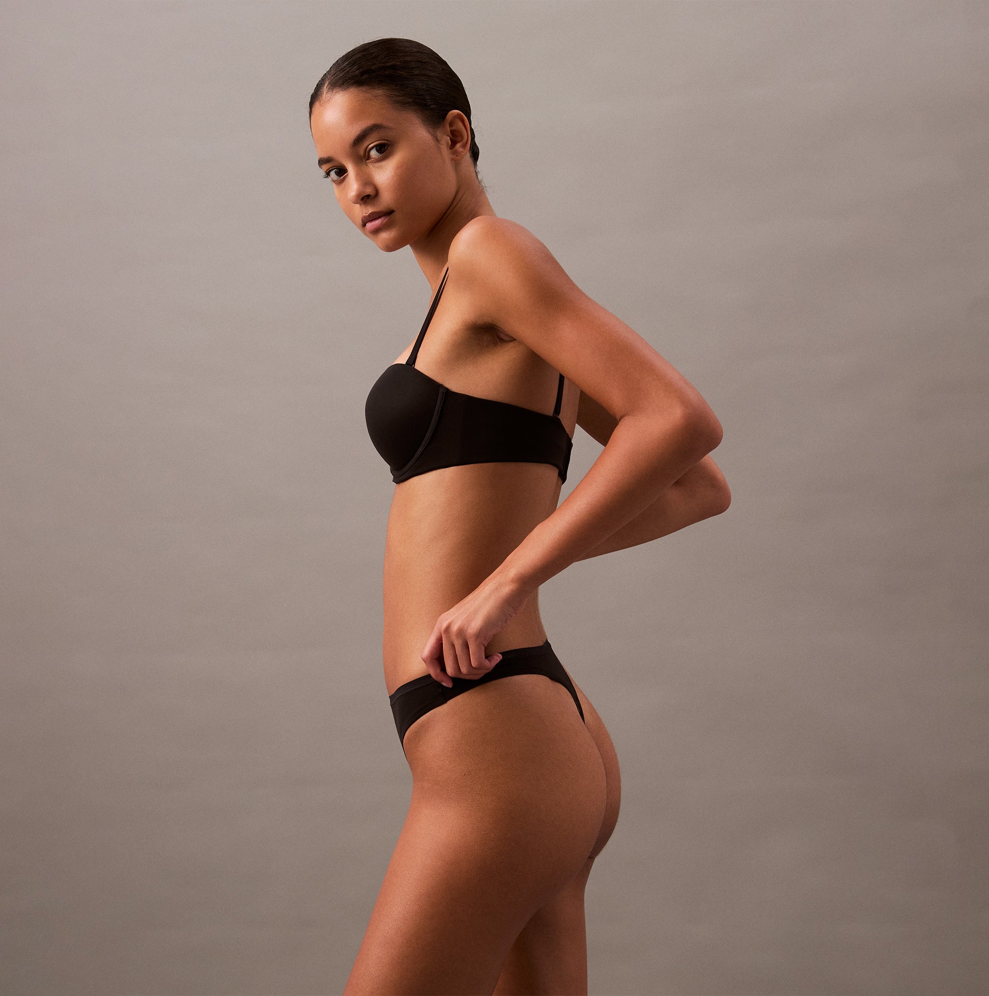 Calvin Klein THONG Womens Perfect Fit Black side view on model, showcasing sleek design and comfortable fit.