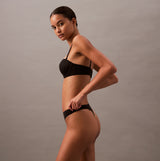 Calvin Klein THONG Womens Perfect Fit Black side view on model, showcasing sleek design and comfortable fit.