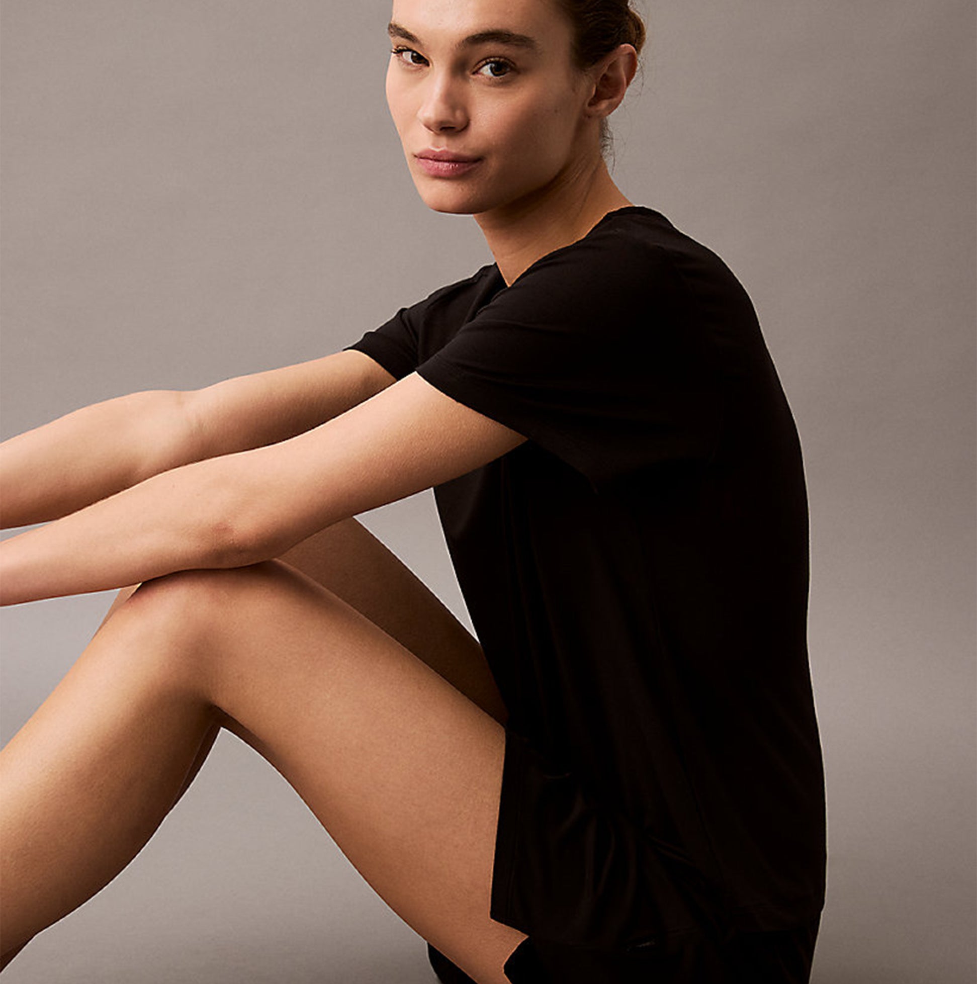 Calvin Klein ULTRA SOFT MODAL Womens Lounge T-Shirt Black worn by model, sitting pose, showcasing short sleeves and relaxed fit.