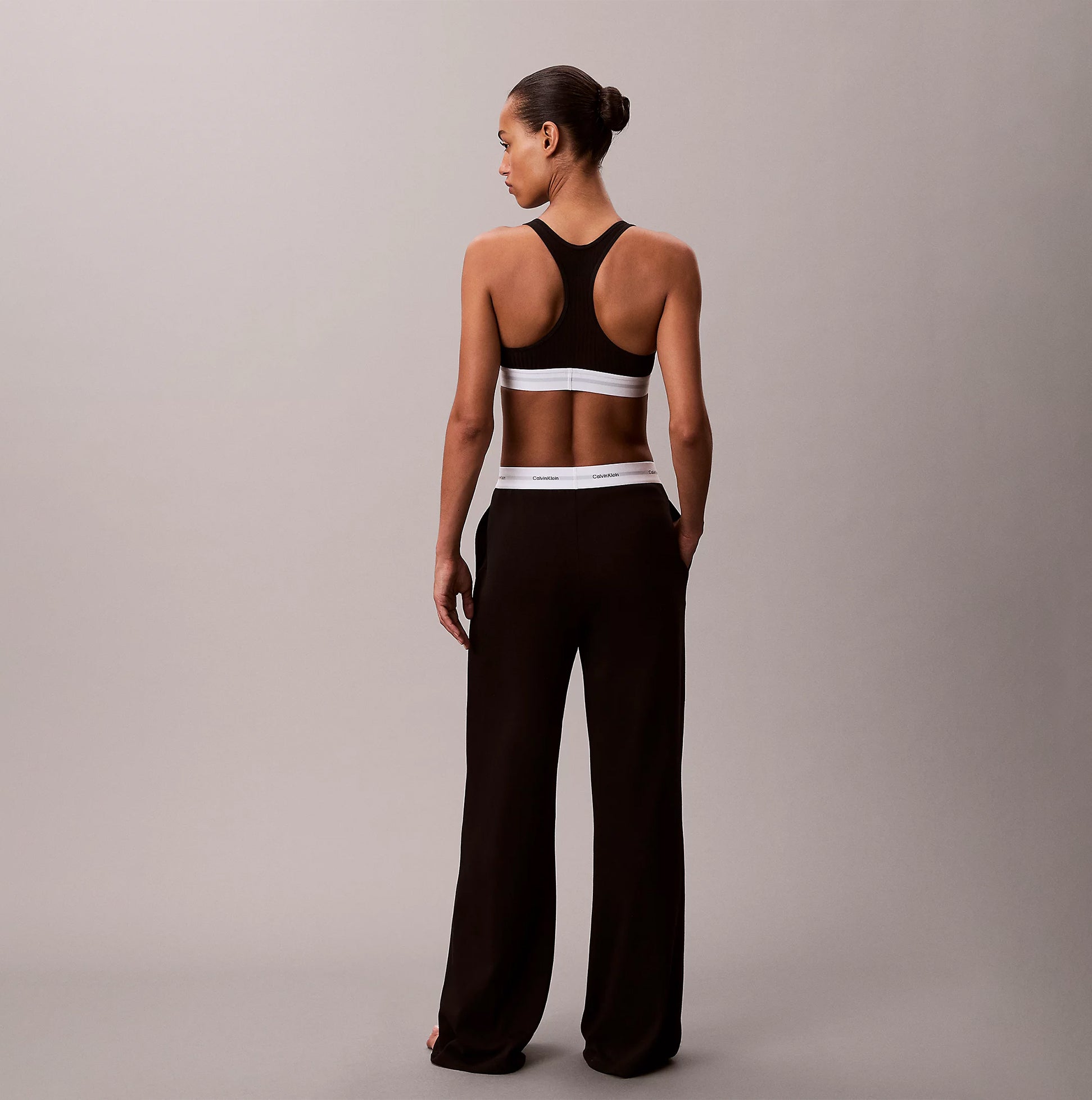 Calvin Klein LOGO JERSEY PANT Womens Black back view on model, showcasing relaxed fit and logo detailing.