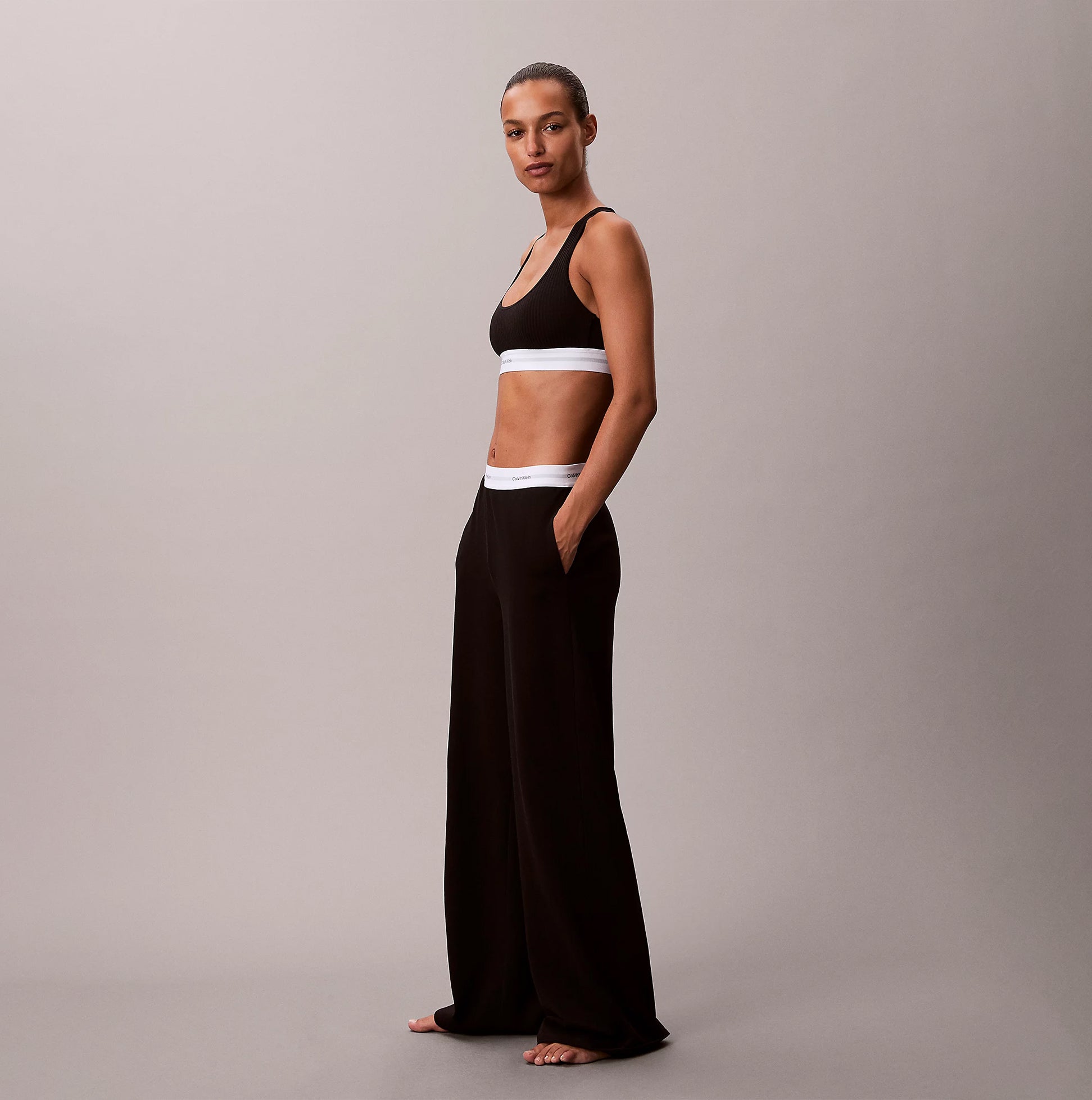 Calvin Klein LOGO JERSEY PANT Womens Black side view, showcasing relaxed fit and pockets.