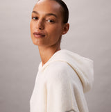 Calvin Klein PLUSH HOODIE. Womens Ivory. Side view of a model wearing the plush hoodie with a soft texture.
