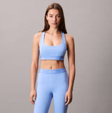 Calvin Klein Womens Quick-Dry Medium Impact Sports Bra Blue front view on model, showcasing a regular fit and athletic style.