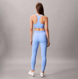 Calvin Klein Womens Quick-Dry Medium Impact Sports Bra Blue back view on model wearing matching leggings.