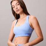 Calvin Klein Womens Quick-Dry Medium Impact Sports Bra Blue front view showing model wearing the blue sports bra with logo.