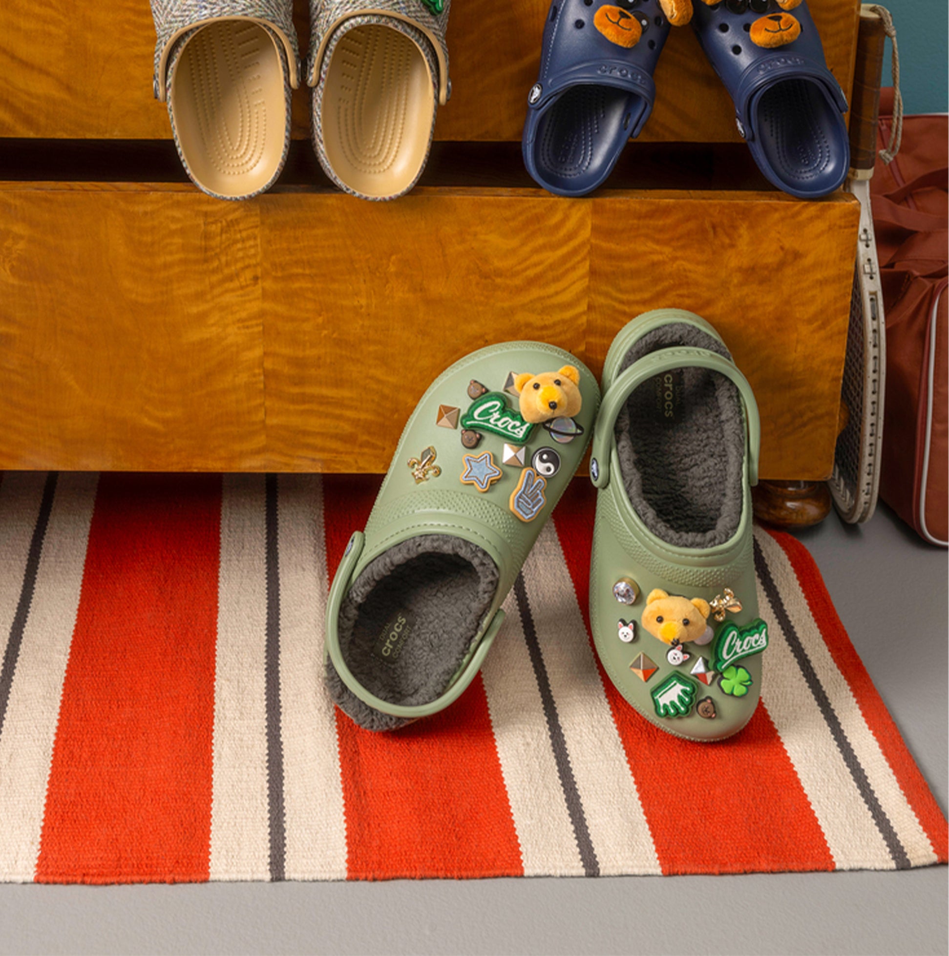Crocs 203591-3WP CLASSIC LINED Unisex Clogs Moss/Multi side view with decorative charms on a striped rug.