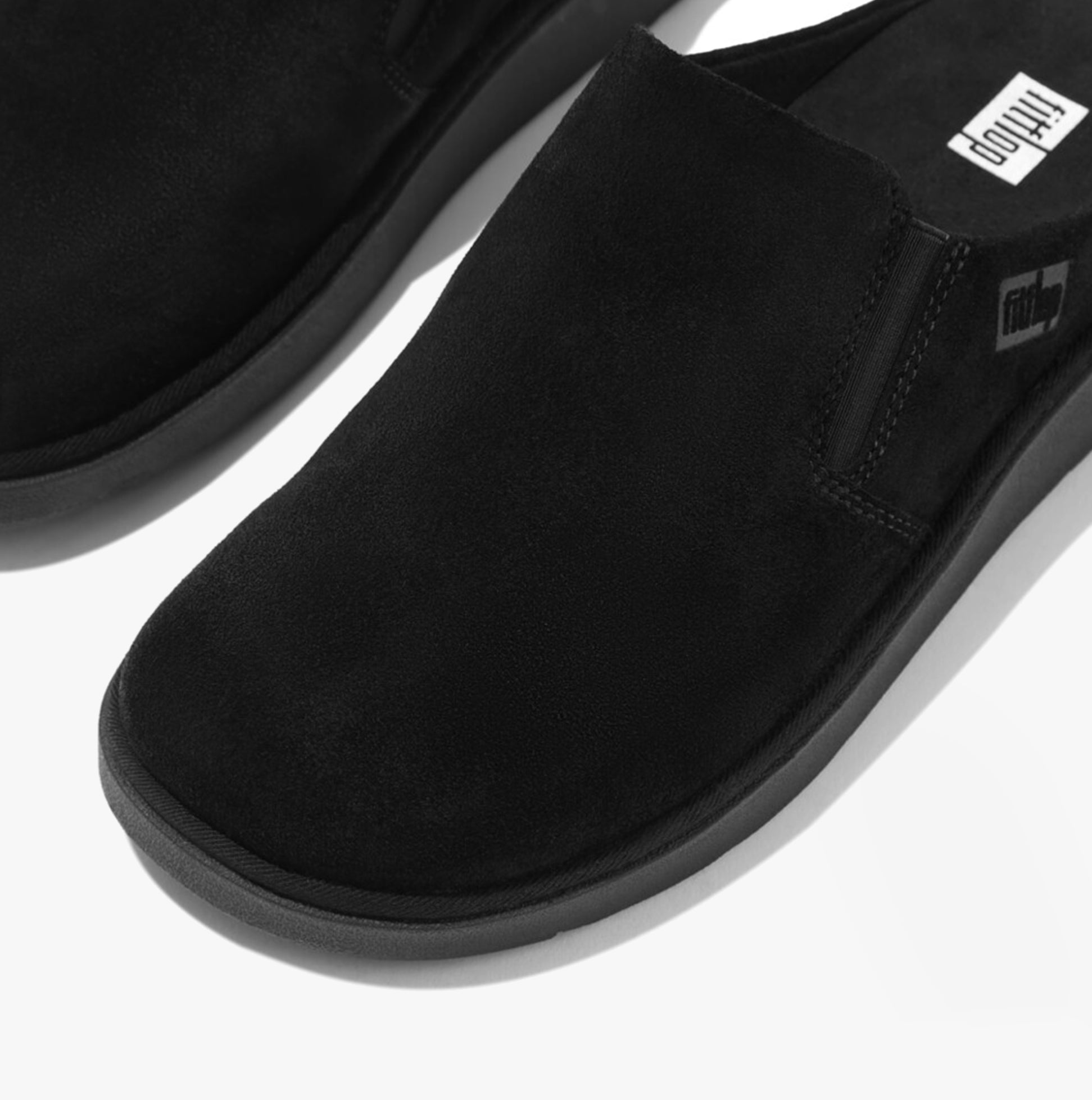 FitFlop GEN-FF Womens Mules Black close-up view, suede upper, slip-on design, comfort-focused footwear.