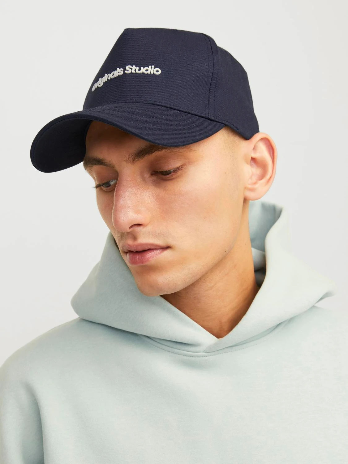 Jack & Jones VESTERBRO Mens Cap Sky Captain front view worn by model with light hoodie.