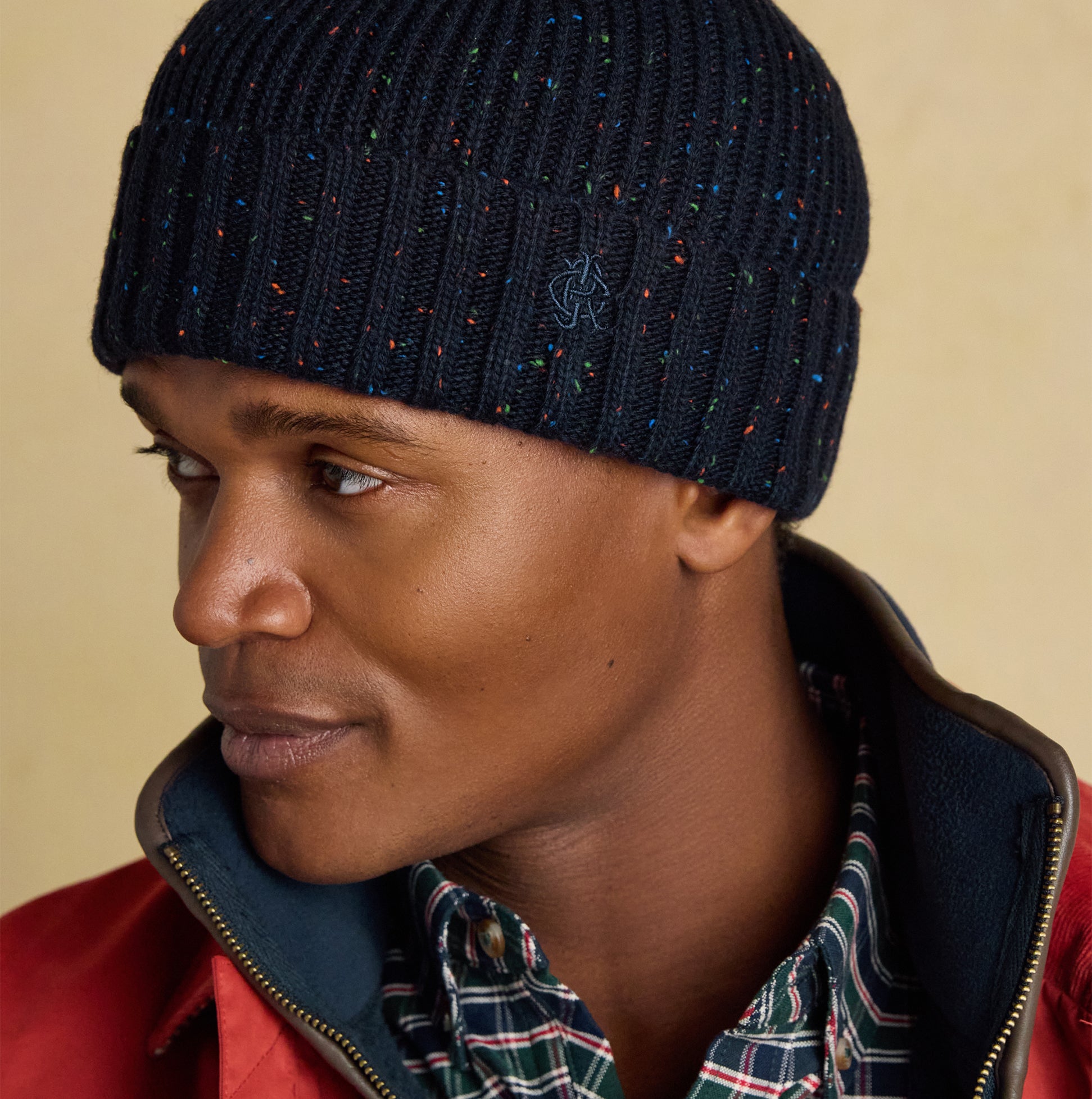 Joules HAMMOND Mens Beanie Navy side view worn by model, showcasing the ribbed design and colorful speckles.