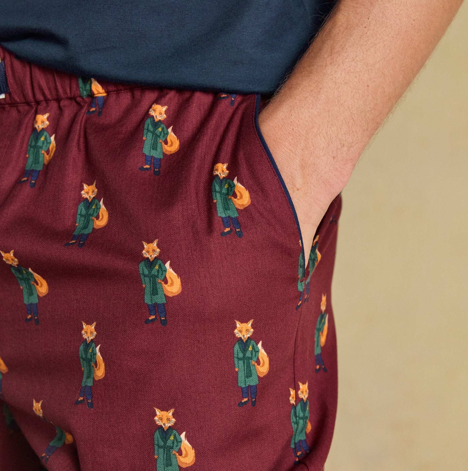 Joules DOZER Mens Pyjama Trousers Burgundy Red detail view showing playful fox pattern and side pockets.