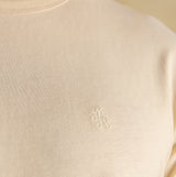 Joules RUGBY CLUB TEE Mens T-Shirt Cream detail view showcasing the embroidered logo on a cream cotton fabric.