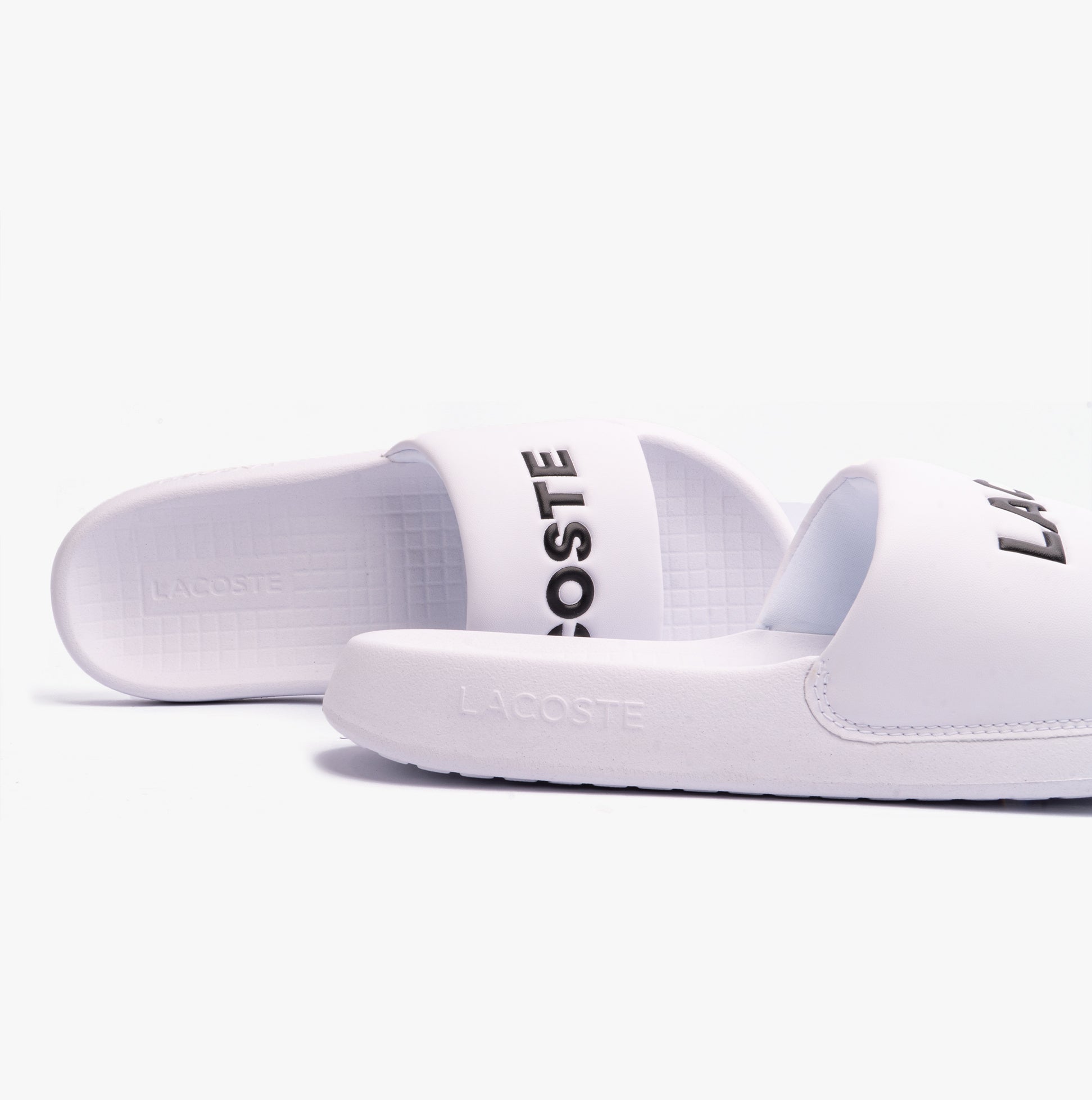 Lacoste SERVE SLIDE 1.0 124 2 Mens Slides White/Black side view showcasing lightweight comfort and slip-on design.