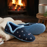 Sleepers ARIA Womens Full Slippers Slippers Navy Blue side view displayed near a fireplace with a cozy setting.