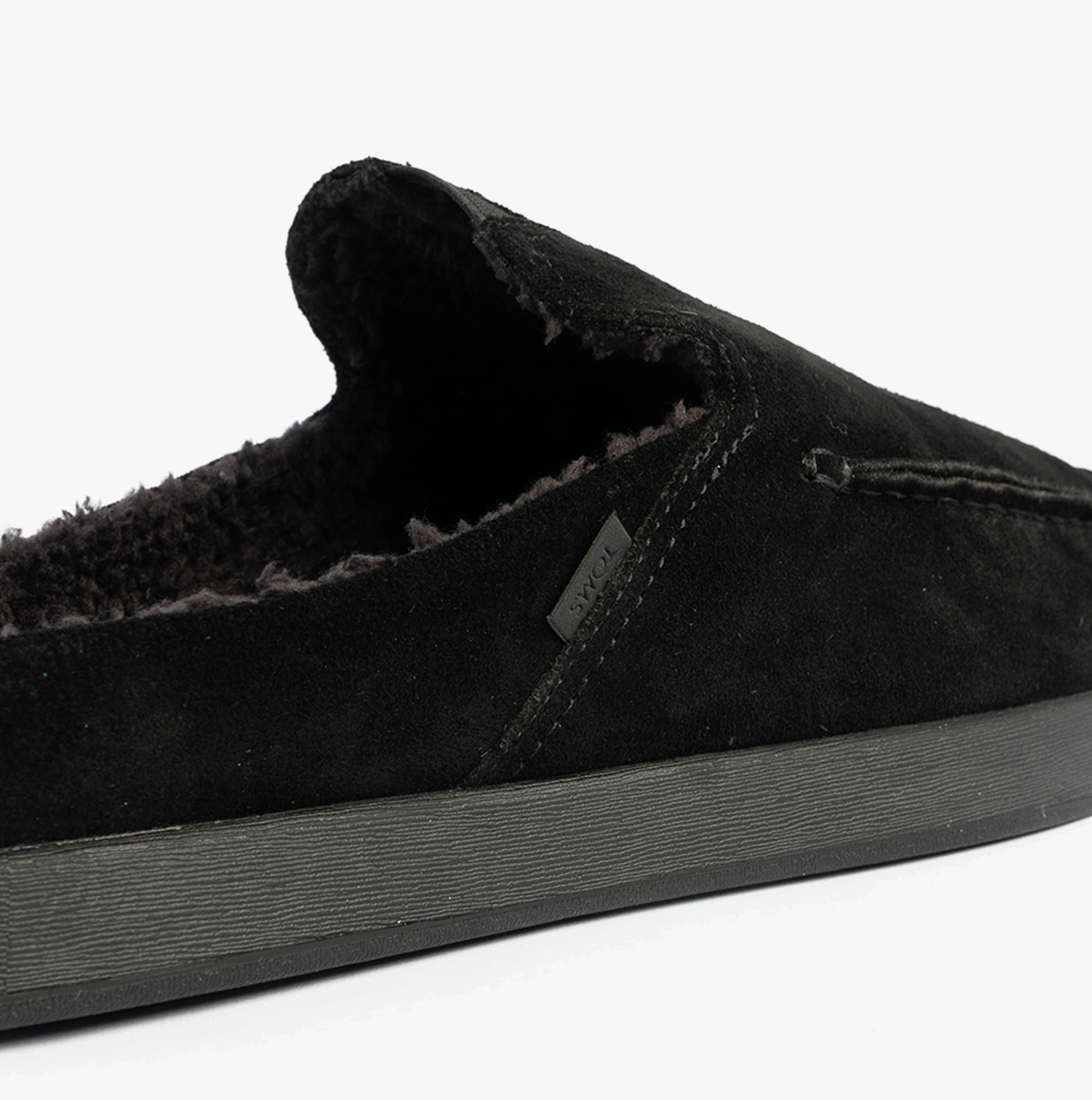 TOMS ALONSO MULE Mens Faux Shearling Lined Slippers Black side view showcasing suede upper and warm shearling lining.