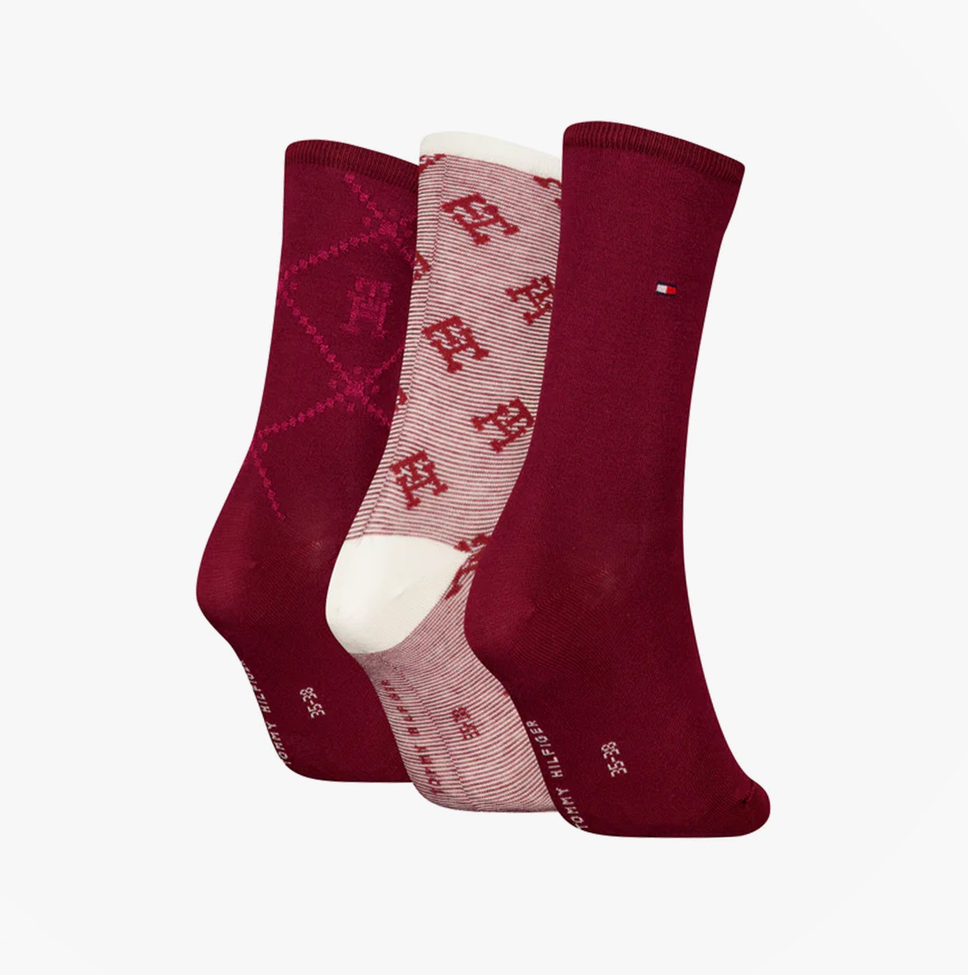 Tommy Hilfiger 3 Pack Giftboxed Monogram Womens Crew Socks Red in a side view showcasing three pairs with varying patterns.