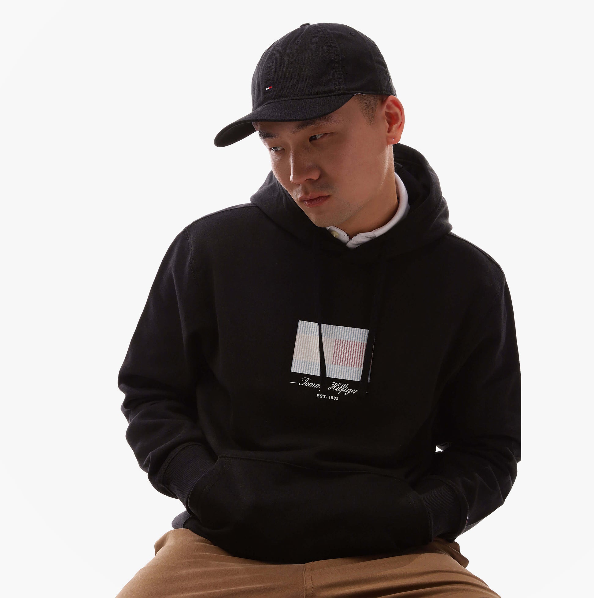 Tommy Hilfiger Flag Baseball Cap Black worn by model with black hoodie, focused view showcasing cap style.