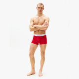 Tommy Hilfiger 3 Pack Trunk Mens Trunks Desert Sky/White/Primary Red side view of red trunk on model with arms crossed.