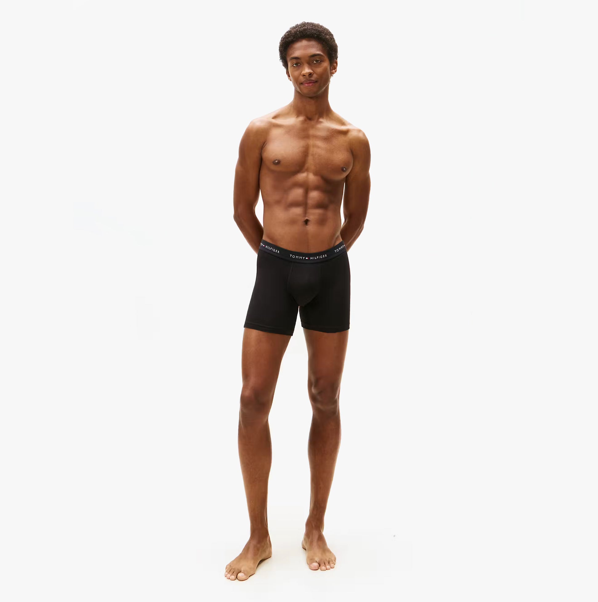 Tommy Hilfiger 3 Pack Mens BOXER BRIEF Black front view on model standing with arms behind back.