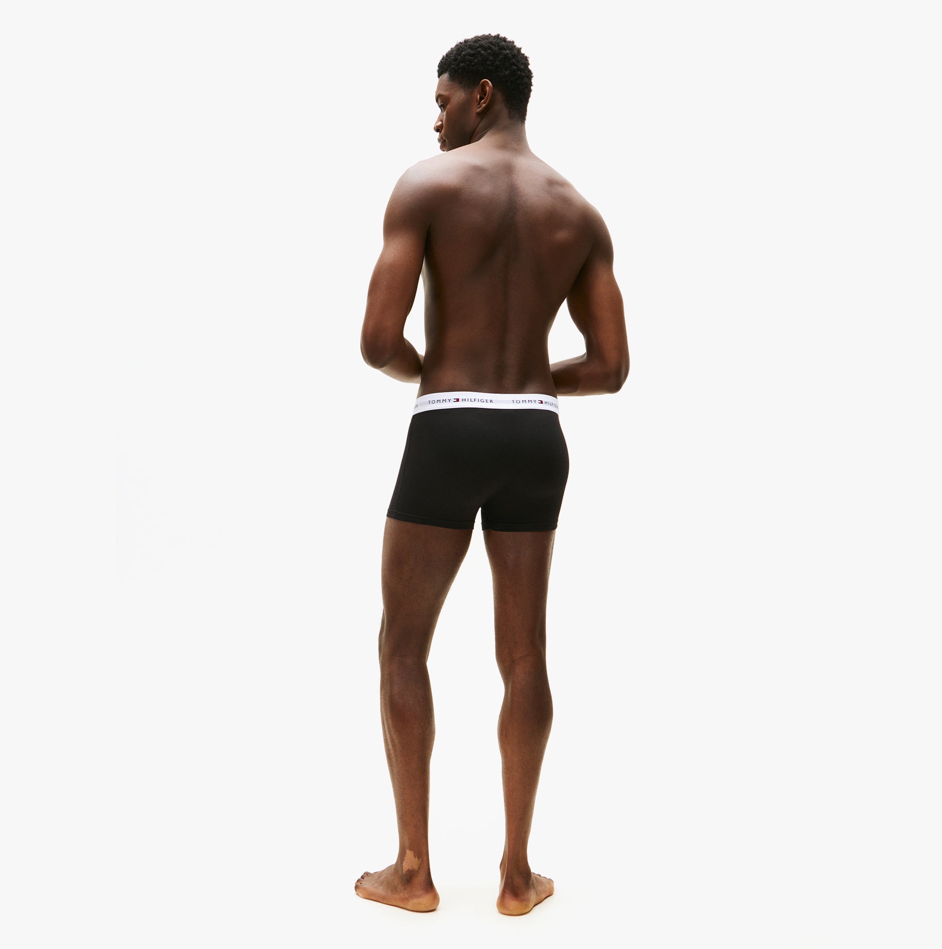 Tommy Hilfiger Mens 3 Pack Trunks Black back view on model, showcasing the design and fit of the underwear.