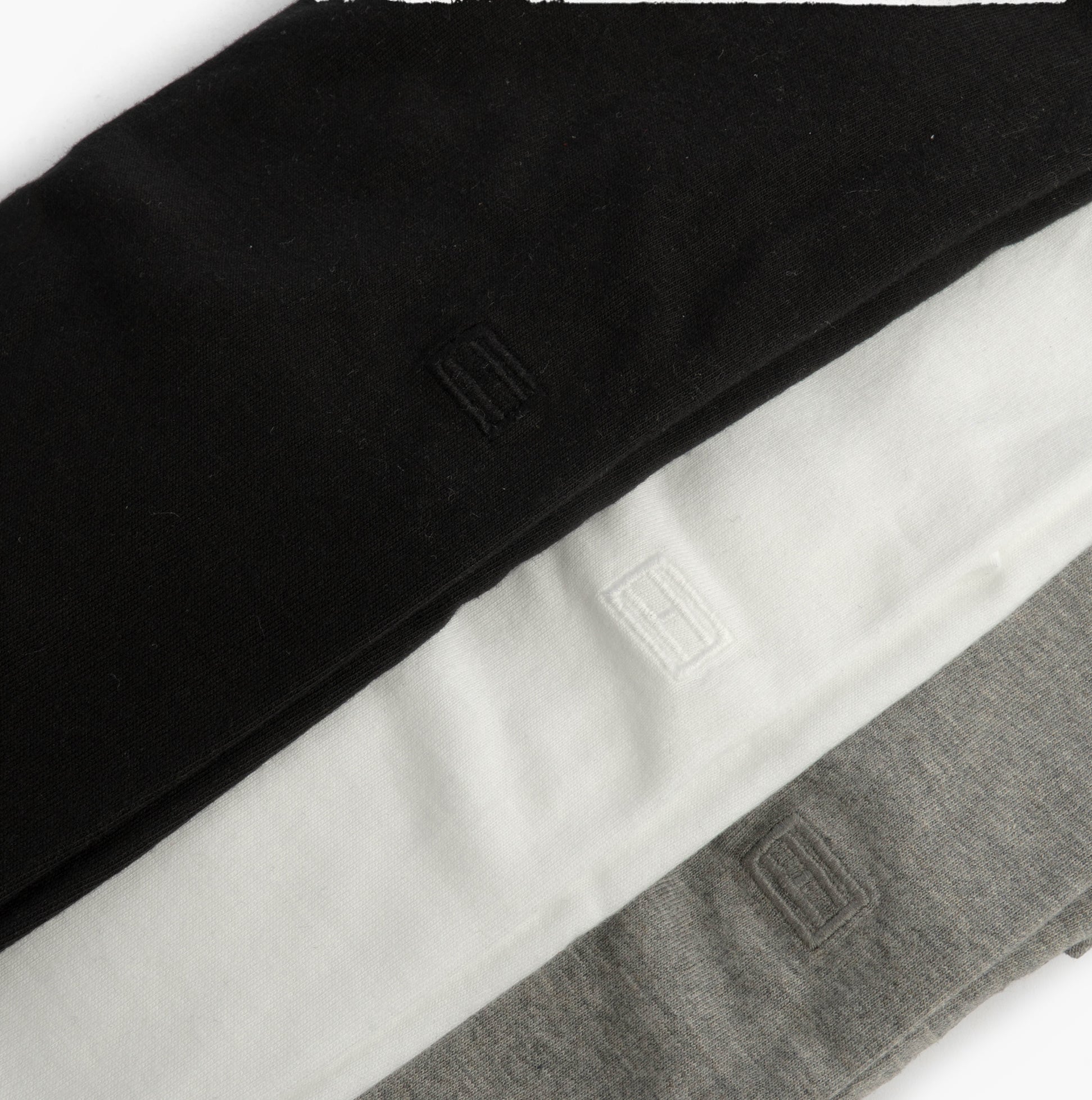 Tommy Hilfiger SS TEE Mens 3-Pack T-Shirts Multicoloured side view of black, white, and grey t-shirts folded neatly.