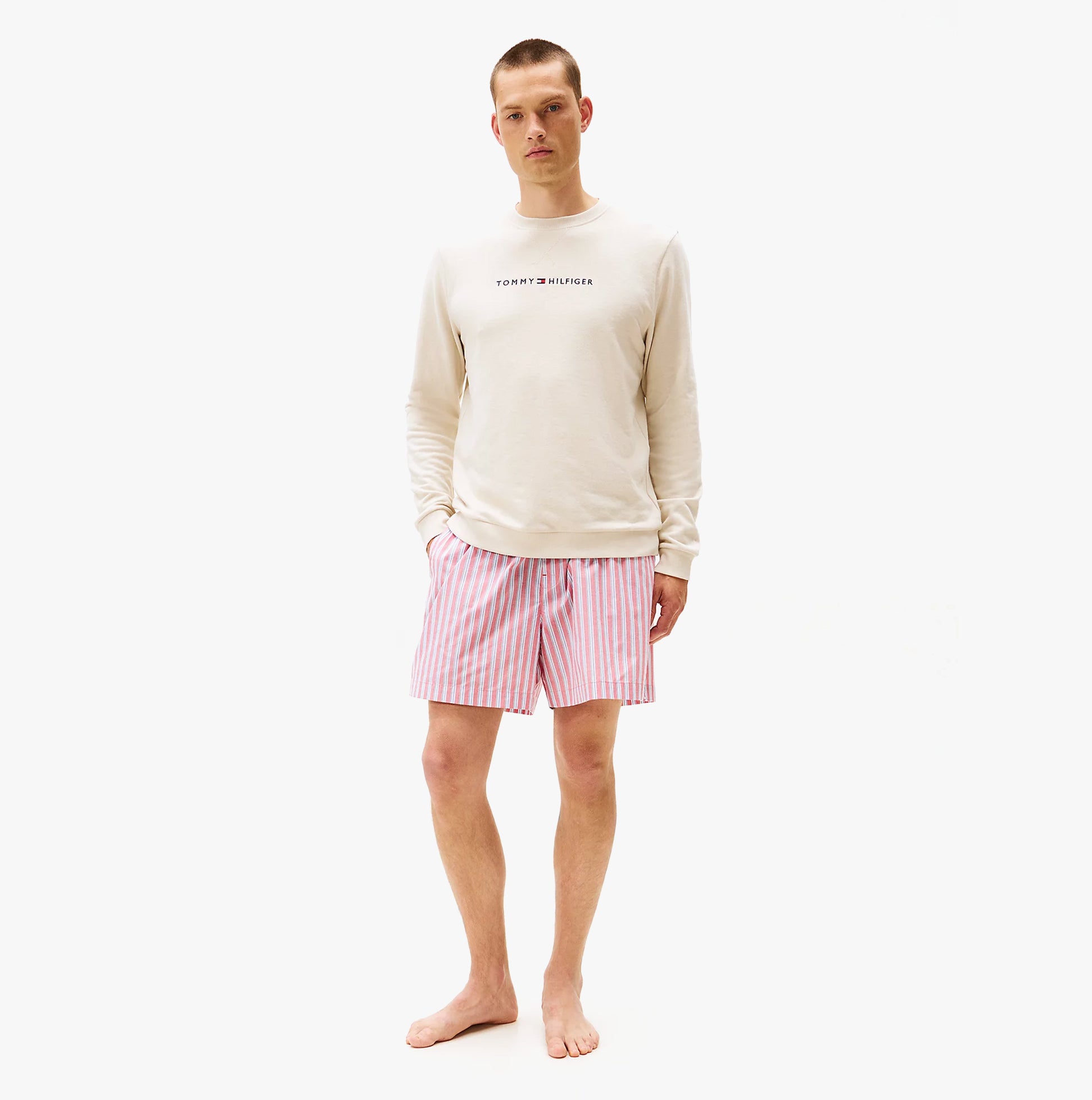 Tommy Hilfiger TRACK TOP Mens Sweatshirts Newsprint front view with model wearing cream sweatshirt and pink striped shorts.