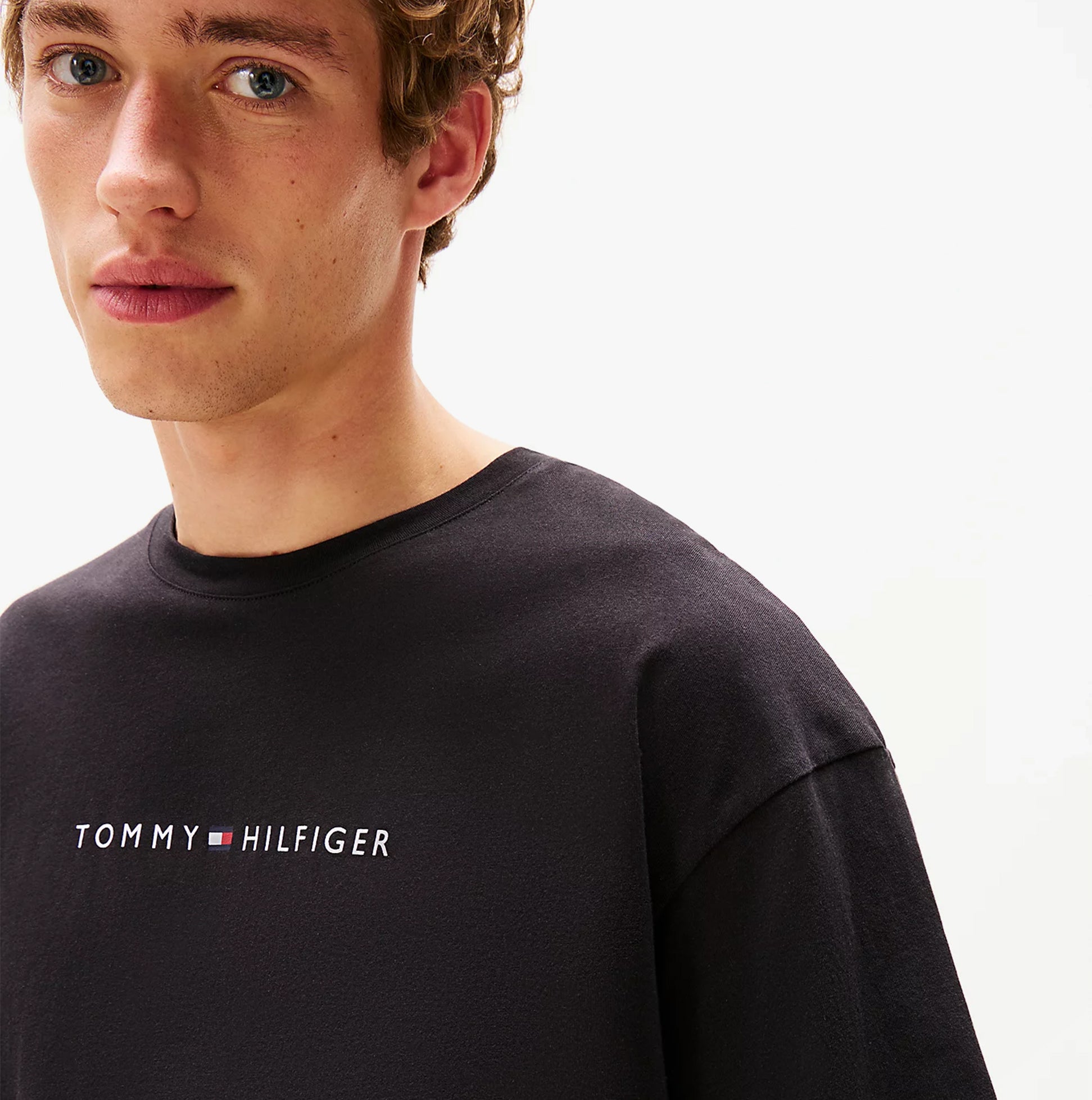 Tommy Hilfiger LOGO T-Shirt Mens Black front view showcasing the logo detail on a model.
