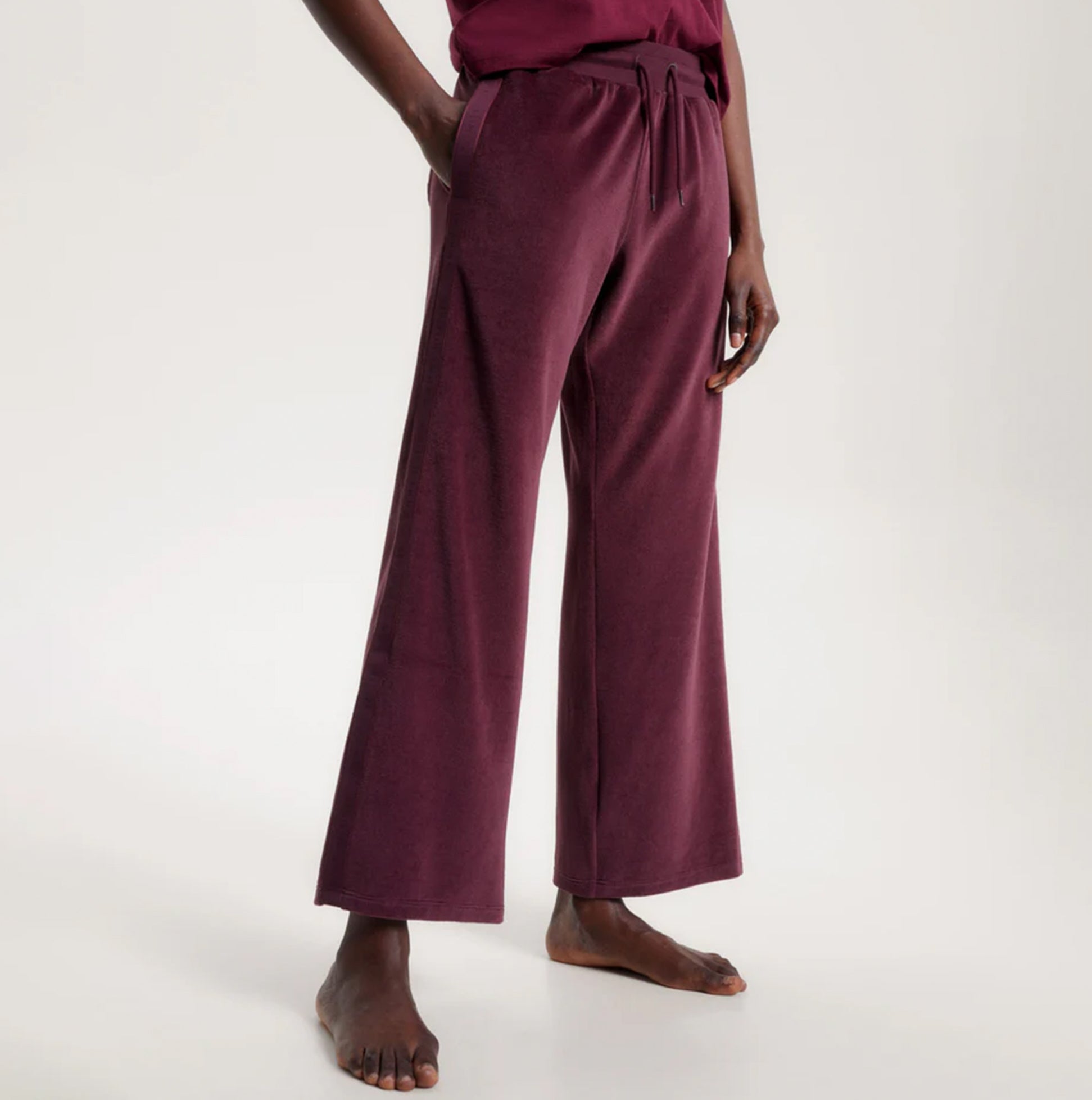 Tommy Hilfiger PANTS VELOUR Womens Pants Deep Burgundy side view showcasing soft fabric and relaxed fit.