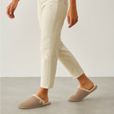Totes Isotoner REAL SUEDE MULE Womens Slippers Sand side view on model wearing cream pants.