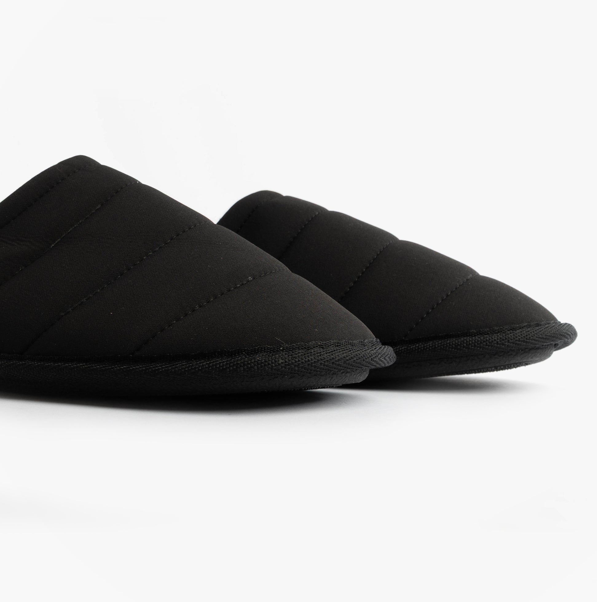 Totes Isotoner SPORT QUILTED MULE WITH COSY LINING Mens Mule Slippers Black side view showing quilted black upper.