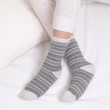Totes Toasties FAIR ISLE Chenille Womens Socks Grey side view on a model's feet, styled with cozy bedding.