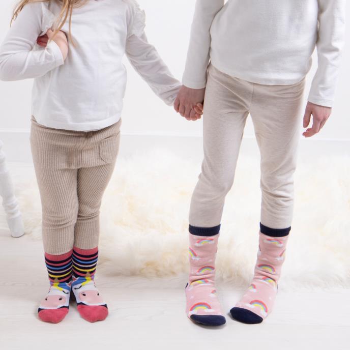 Totes Toasties ORIGINAL Slipper Socks (Twin Pack) Unisex Kids Socks Unicorn, side view of kids wearing colorful socks holding hands.